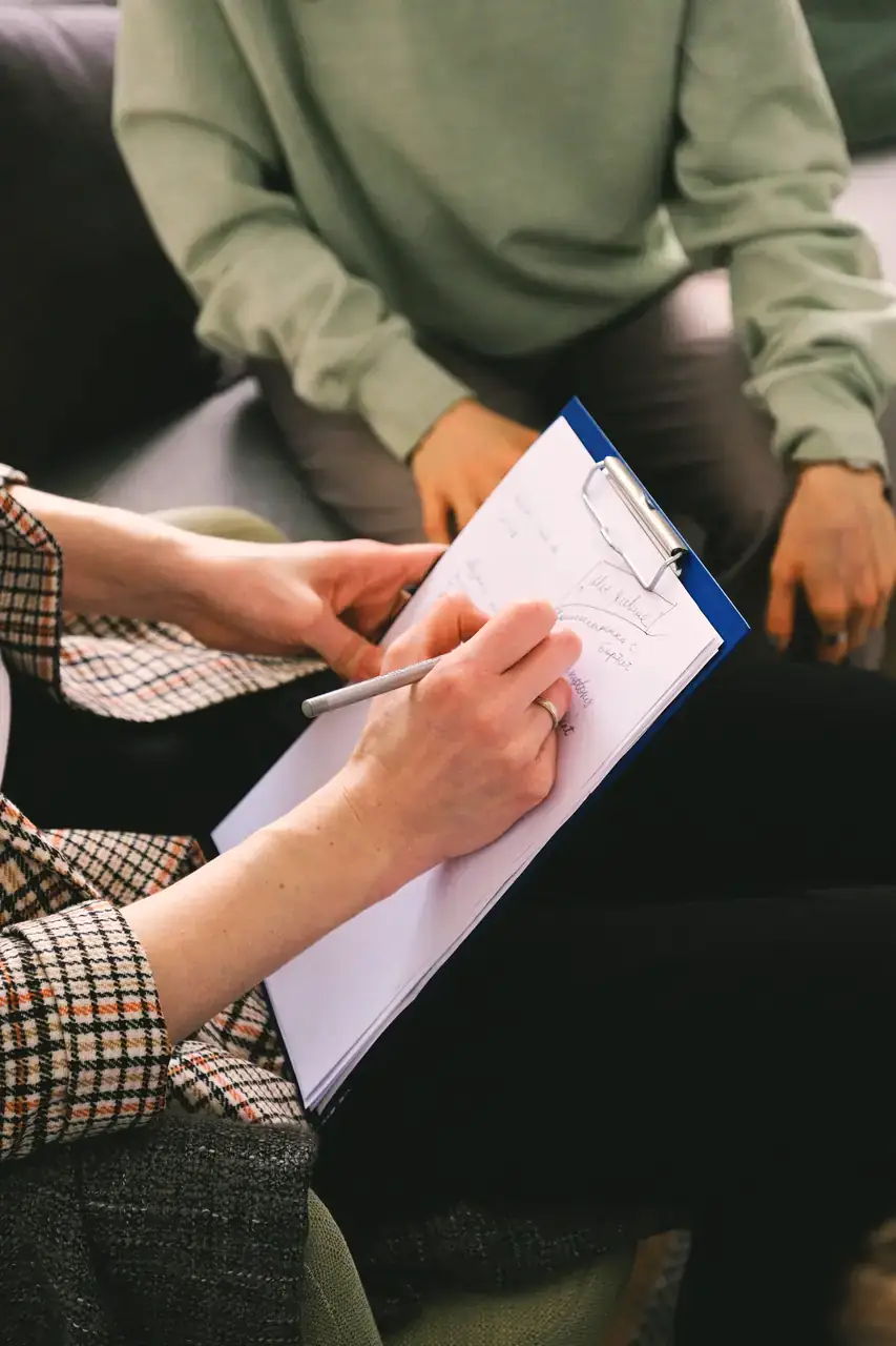 A dietitian taking notes on a clipboard during a consultation