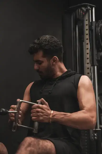 A man training on a cable machine in a gym