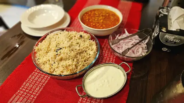 Jeera rice, dal and raita on a red table runner